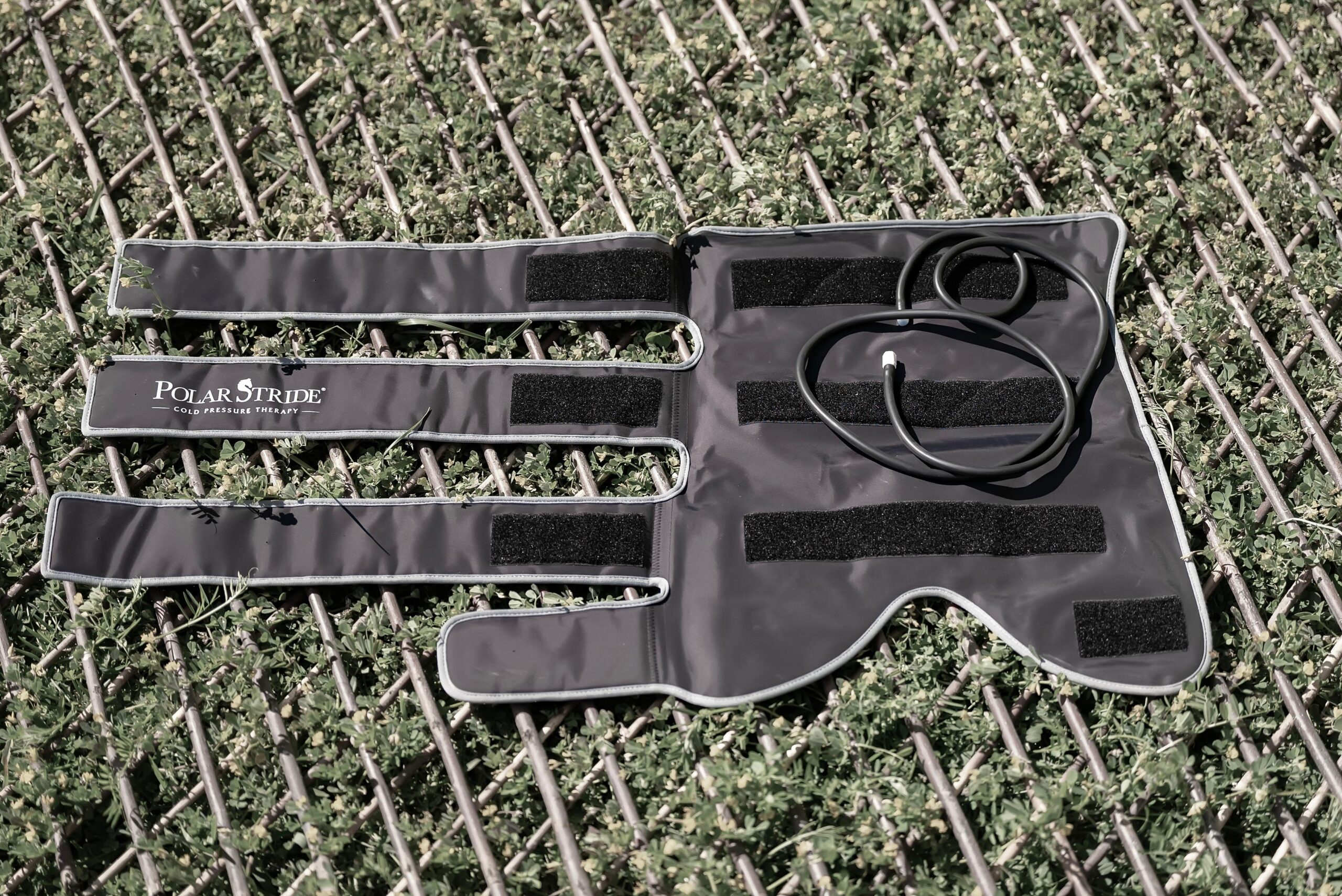 Polar Stride cold-compression wrap fully opened, revealing the internal velcro pads and tube connection