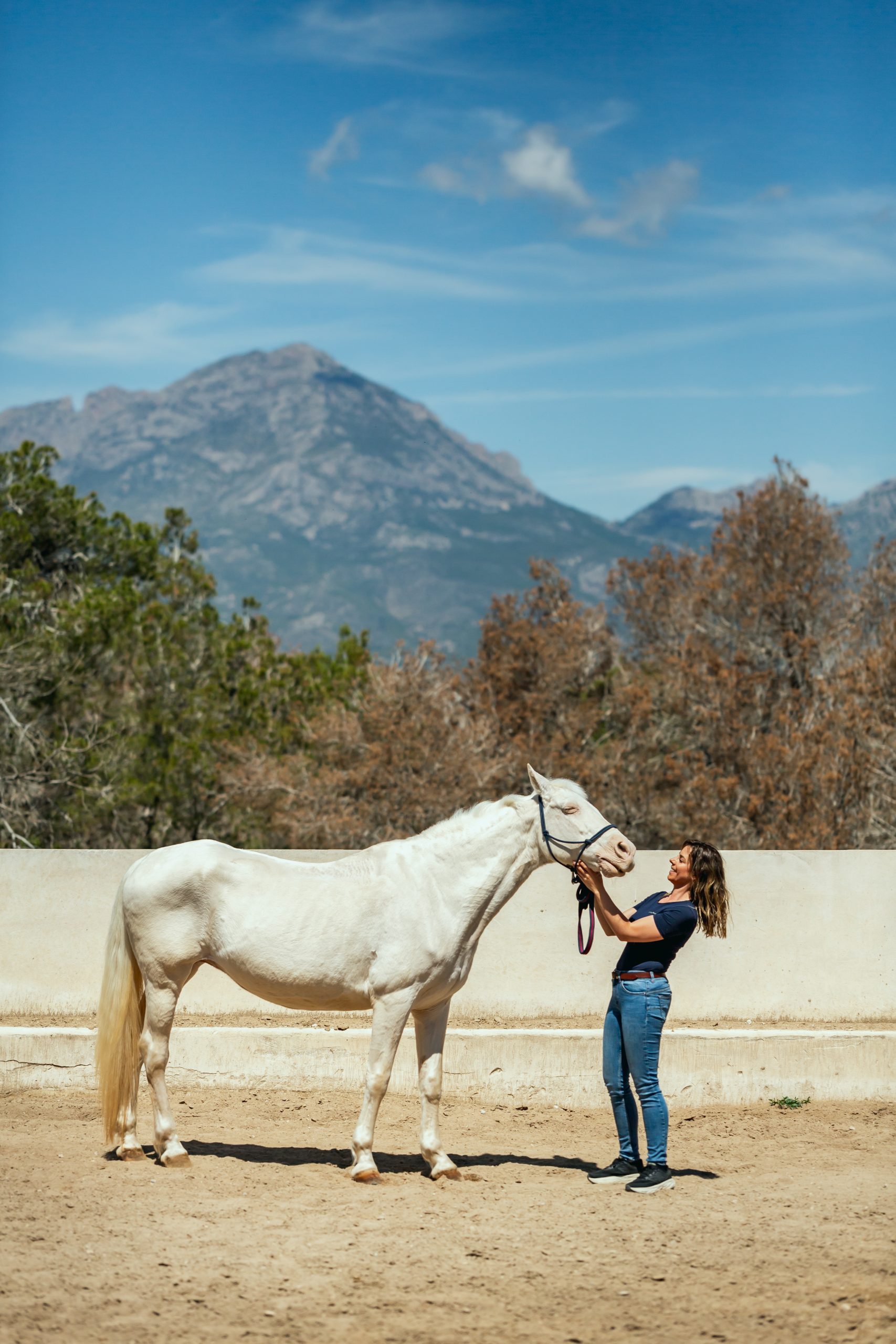 Happy horse owner holding Polar Stride device next to horse
